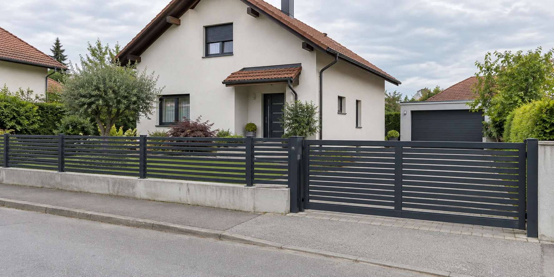 The same house with a steel fence and driveway gate